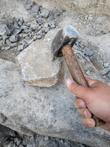 In den Herkimer Diamantenminen in Herkimer New York mit einem Vorschlaghammer auf einen Felsen schlagen