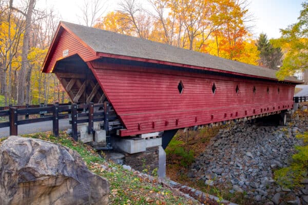 Fall foliage behind Newfield Covered Bridge in Newfield New York