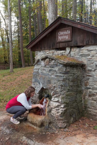 Woman trying water from Orenda Spring in Saratoga Spa State Park in New York