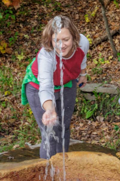 Woman drinking from Polaris Spring in Saratoga Spa State Park in New York