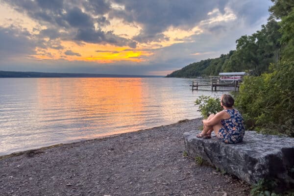 Woman enjoying the sunset on Cayuga Lake in Ithaca NY