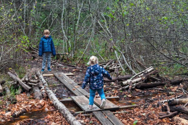 Kids crossing a bridge on the hike to Death Brook Falls in Raquette Lake New York