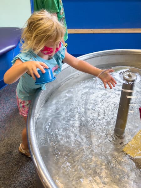 Girl playing at a water table at the Sciencenter in Ithaca NY