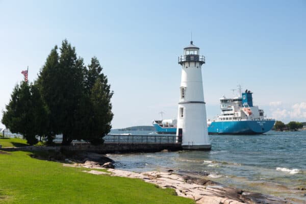 Giant cargo shipping passing behind the Rock Island Lighthouse near Clayton New York