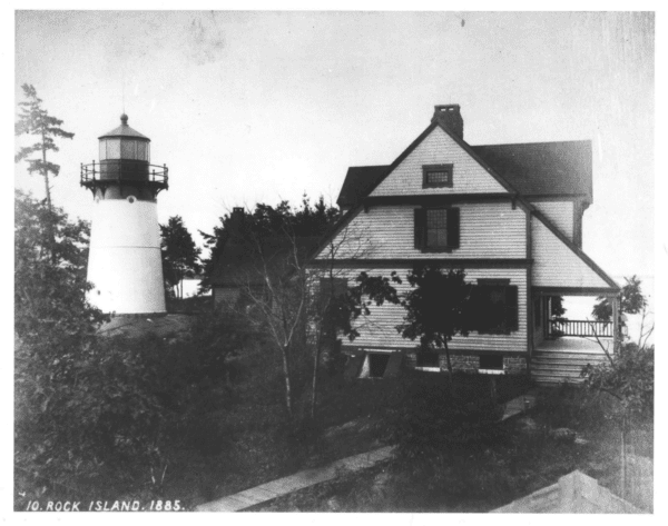 A historic black and white photo of Rock Island Lighthouse before it was moved to its current location.