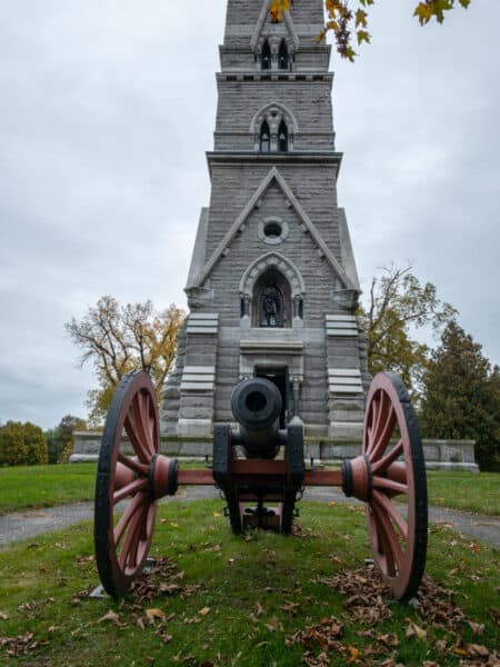 A canon sits in front of the granite Saratoga Monument in Victory NY