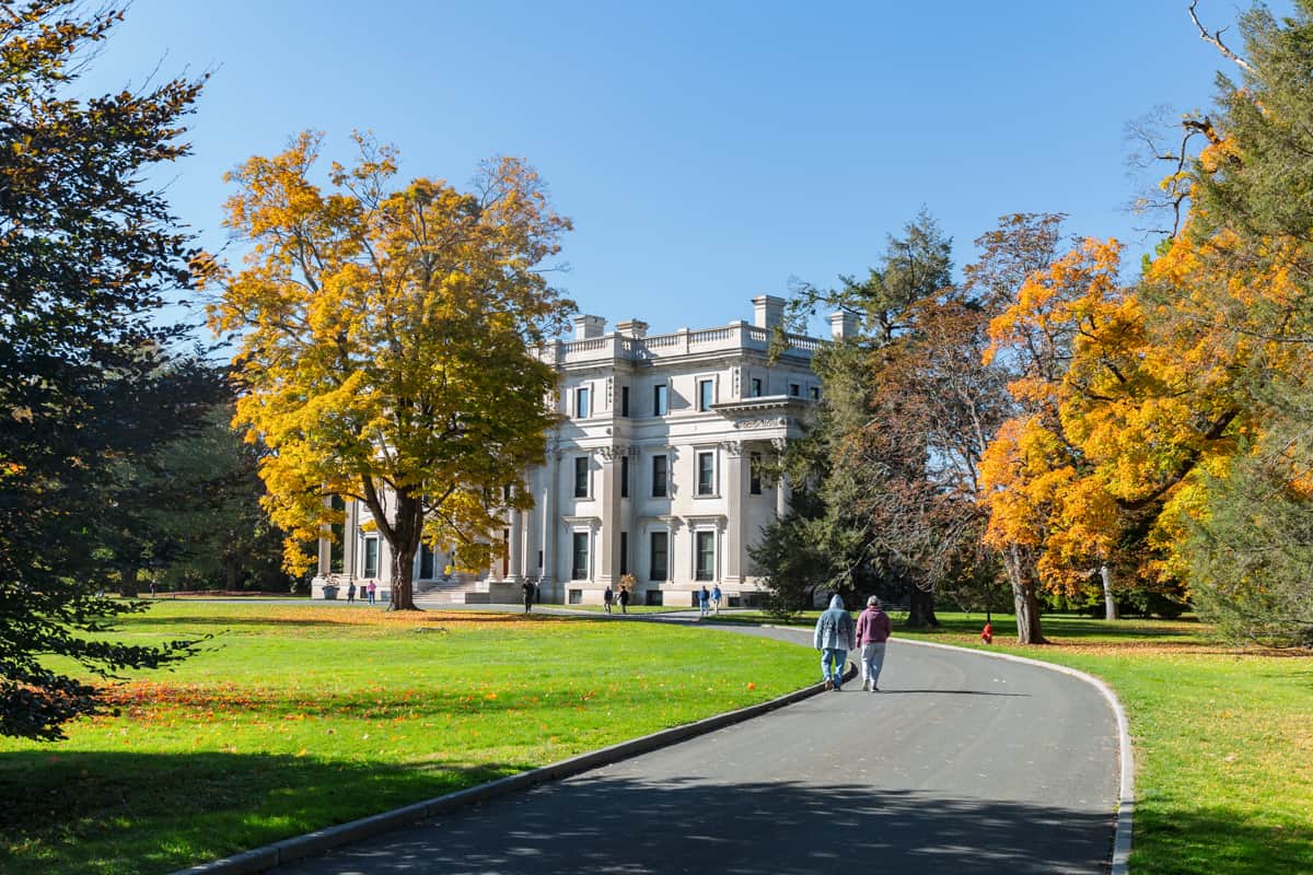 People walking towards the exterior of the Vanderbilt Mansion National Historic Site in Hyde Park, NY